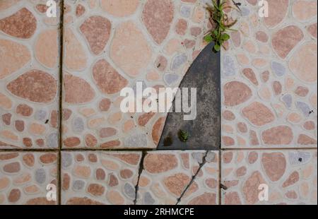 The floor tiles were broken and fell off. caused by usage and lifespan of the material Stock Photo