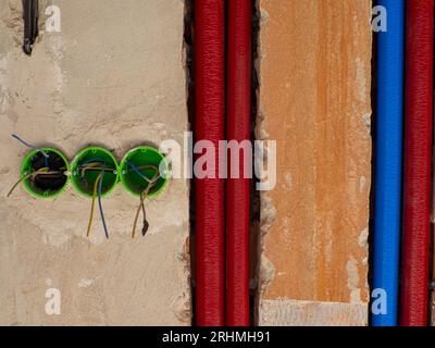 Plastic backbox for sockets or switches inserted into the drilled holes on wall Stock Photo