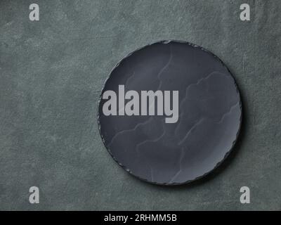 empty black plate on dark grey background, top view Stock Photo