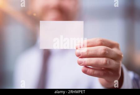 Man's hand showing business card - closeup shot Stock Photo