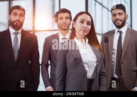 Group of young successful business team looking at camera while having a meeting in the modern office and coworking space Stock Photo