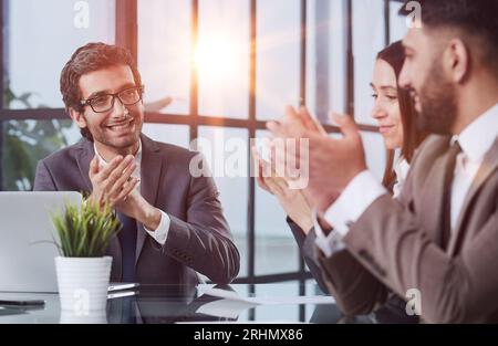 Glad to be part of the creative team. Group of cheerful business people sitting together at the table and discussing something Stock Photo