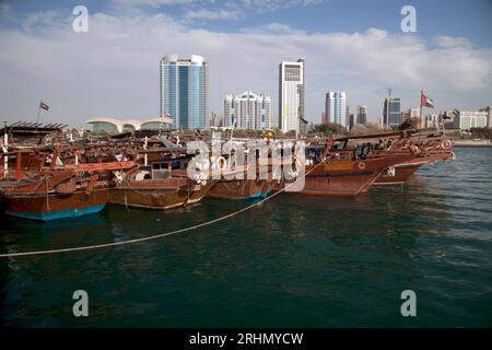 United Arab Emirates, Abu Dhabi, skyline as seen from the fish souk (Mina fish market) with moored dhows in the foreground. Stock Photo