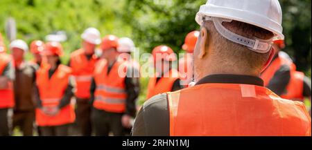 Helmet builder. Many construction workers helmet. Team in hardhat for work. Worker group wearing vest, safety. Building concept. Engineers on Stock Photo