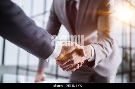 Handshake of two businessmen who enters into the contract to develop a new software to improve business service at a company. Stock Photo