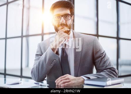 Image of a successful businessman rubbing his beard having an interesting idea while sitting in a modern office Stock Photo