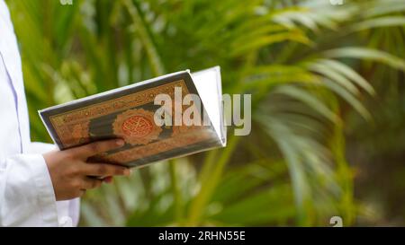 Holding and reading Quran, the Islamic holy book Stock Photo