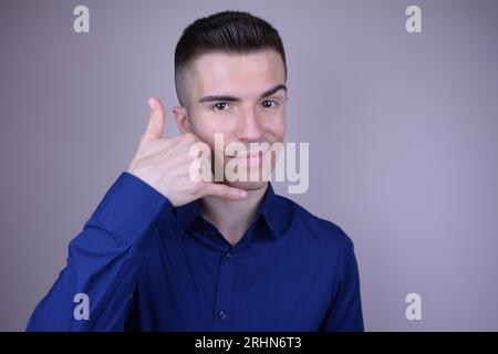 Elegant Young Handsome Smiling Caucasian Man Showing Phone Call Me Gesture - Isolated Background Stock Photo