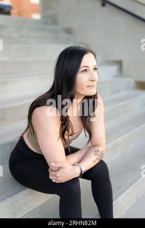 A woman sitting on cement stairs Stock Photo