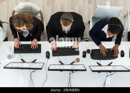 High Angle View Of Call Center Operators Working On Computers In Office Stock Photo
