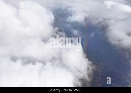 Rainbow view from above in clouds . Clouds and sky as seen through window of an aircraft Stock Photo