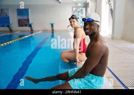 Joyous swimmers posing for camera at poolside Stock Photo