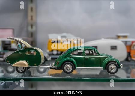 Toy or model  green Volkswagen bug with camping trailer on display. Stock Photo