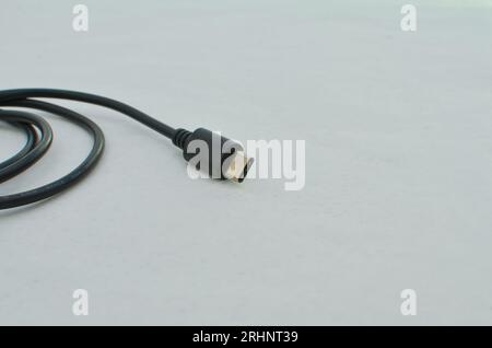 Black USB Type-C cable detail highlighted on a clear surface, perfect for modern technology concepts. Close-up black USB Type-C cable providing speed Stock Photo