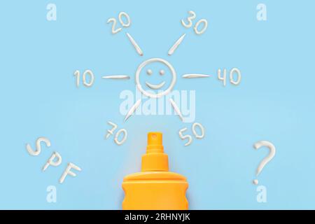 sunscreen, orange bottle, sun protection on blue background. spray to protect against sunburn. different spf values for sun protection cream Stock Photo