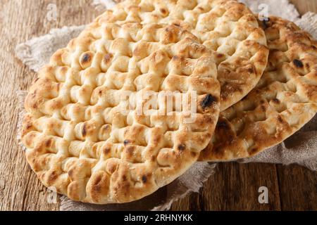 Authentic whole greek pita bread closeup on the wooden table. Horizontal Stock Photo