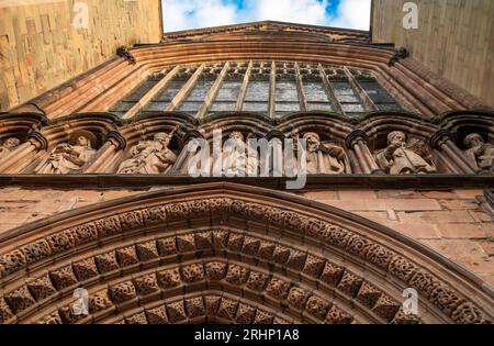 Carved figures on a ledge on the front of  Lichfield Cathedral in Staffordshire, UK,  above the elaborate central arch on the front elevation and belo Stock Photo