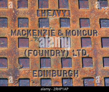 Heavy cast iron grid embossed with Mackenzie & Moncur (Foundry) Ltd, Edinburgh, Scotland, UK, EH1 3QB Stock Photo