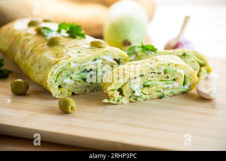 vegetable zucchini roll with garlic cheese filling inside, on a wooden board. Stock Photo