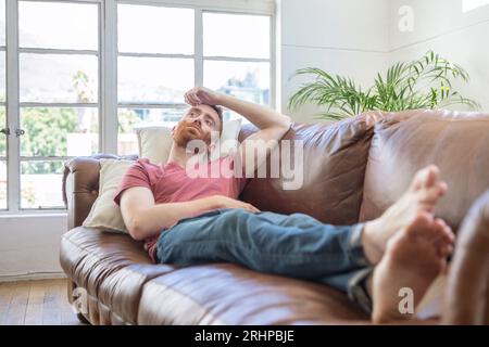 Young man lying on sofa Stock Photo