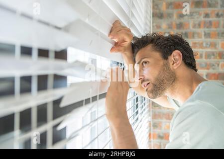 Man looks out of the window Stock Photo