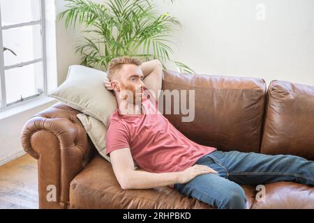 Young man lying on sofa Stock Photo
