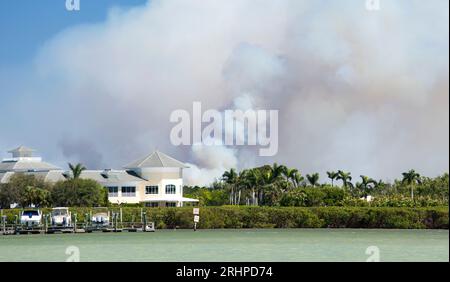 Naples, Florida, USA. Smoke clouds above Naples Bay rising from a brush fire in Picayune Strand State Forest caused by an escaped prescribed burn. Stock Photo