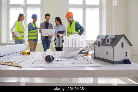 Engineers and architects standing on a building site with architectural plan. Stock Photo