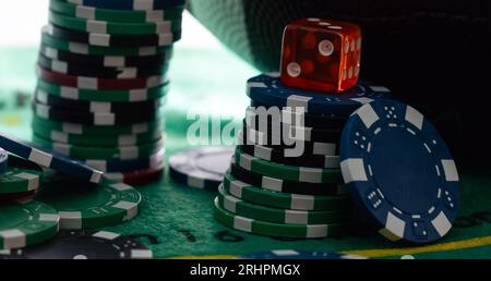 Image of several red dice falling on green table on background of multicolored spots Stock Photo