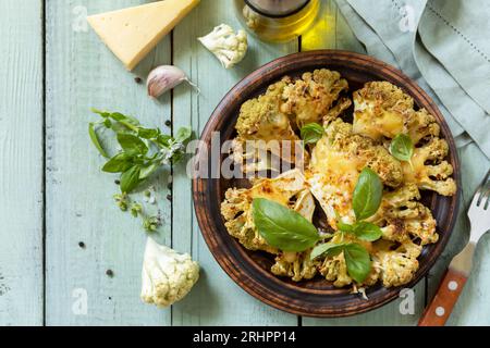 Healthy eating, plant based meat substitute concept.Vegetarian organic food. Baked cauliflower steaks with herbs and spices on a wooden table. View fr Stock Photo
