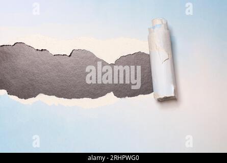 Torn paper with opening showing black background Stock Photo