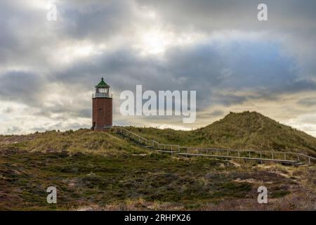 Lighthouse 'Quermarkenfeuer Rotes Kliff' near Kampen on Sylt with dramatic cloud cover Stock Photo