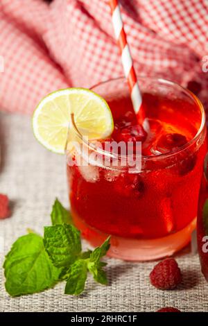 Homemade raspberry lemonade. Non-alcoholic cold drink in a misted glass. Selective focus. Stock Photo