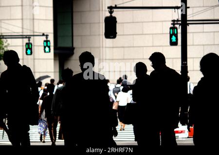 Daily Life in Japan 'Silhouettes of people commuting to work from Tokyo Station in the morning' Stock Photo