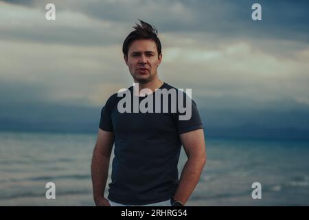 Portrait of a serious handsome young man on the seashore Stock Photo