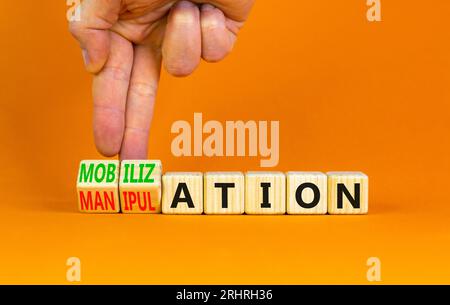 Mobilization or manipulation symbol. Concept words Mobilization Manipulation on wooden cubes. Beautiful orange background. Psychologist hand. Psycholo Stock Photo