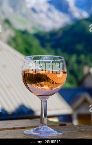 Drinking of dry dry rose wine from Savoy region with view on Hautes Alpes mountains with snow on tops Stock Photo