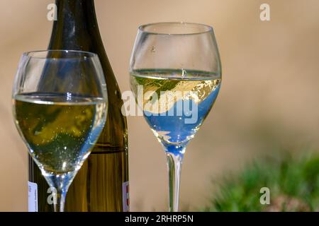 Glass and bottle of dry white Roussette de Savoie or Vin de Savoie wine from Savoy region served on Col du Galibier border Savoy region, France, view Stock Photo