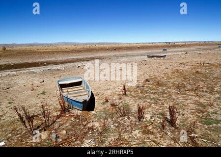 Lake Titicaca, BOLIVIA; August 18th 2023: Wooden rowing boats on the dried up shore of Cohana Bay on the Inner Lake / Huiñay Marka (the smaller part of Lake Titicaca) near the village of Cohana. Water levels in Lake Titicaca are approaching the record low level set in 1996, the lowest since Bolivia's weather service (Senhami) started keeping records in 1974. Many are blaming climate change; the last few years have been drier than normal and El Niño is currently strengthening in the Pacific Ocean off South America. Stock Photo