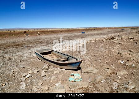 Lake Titicaca, BOLIVIA; August 18th 2023: Wooden rowing boats on the dried up shore of Cohana Bay on the Inner Lake / Huiñay Marka (the smaller part of Lake Titicaca) near the village of Cohana. Water levels in Lake Titicaca are approaching the record low level set in 1996, the lowest since Bolivia's weather service (Senhami) started keeping records in 1974. Many are blaming climate change; the last few years have been drier than normal and El Niño is currently strengthening in the Pacific Ocean off South America. Stock Photo