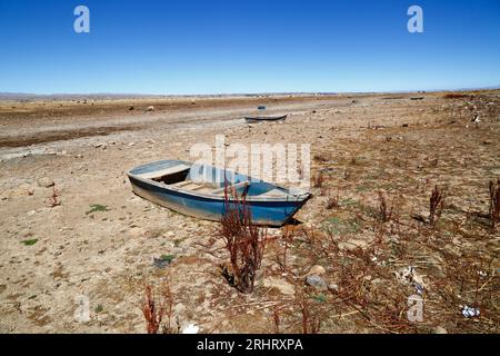 Lake Titicaca, BOLIVIA; August 18th 2023: Wooden rowing boats on the dried up shore of Cohana Bay on the Inner Lake / Huiñay Marka (the smaller part of Lake Titicaca) near the village of Cohana. Water levels in Lake Titicaca are approaching the record low level set in 1996, the lowest since Bolivia's weather service (Senhami) started keeping records in 1974. Many are blaming climate change; the last few years have been drier than normal and El Niño is currently strengthening in the Pacific Ocean off South America. Stock Photo