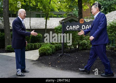 United States President Joe Biden greets South Korean President Yoon Suk Yeol near the Camp David sign at the Trilateral Summit at Camp David, the presidential retreat near Thurmont, Maryland on August 18, 2023. Credit: Nathan Howard/Pool via CNP Stock Photo