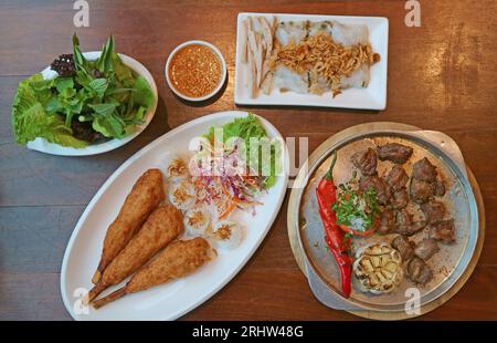 Delectable Popular Vietnamese Dishes Served on Wooden Table Stock Photo