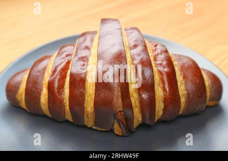Closeup of a Delectable Bicolored Chocolate Croissant Served on Wooden Table Stock Photo