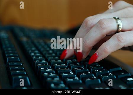 office working lady fingered on computer or laptop black keyboard in close up Stock Photo