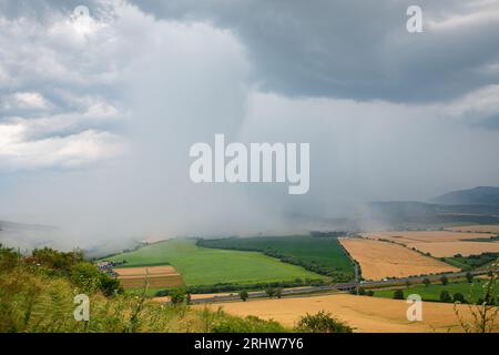 Distinct rain shaft from a thunderstorm over a hilly countryside in Prešov Region, Slovakia. Stock Photo