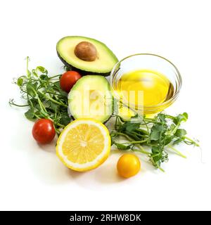 Ingredients of healthy food. Micro green pea sprouts, olive oil, tomato, avocado, lemon. Ketogenic low carbs diet concept. Isolated on a white backgro Stock Photo