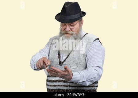 Portrait of old man scrolling mockup tablet pc. Isolated on white. Stock Photo