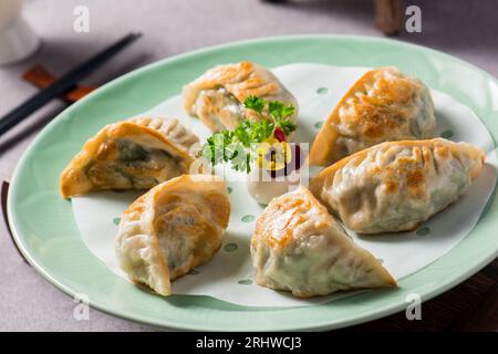 Fried dumplings Gyoza on a plate on a gray concrete background, top view Stock Photo