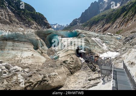 Tourists visiting the Ice Cave dug into The Mer de Glace ('Sea of Ice'), a valley glacier located on the northern slopes of the Mont Blanc massif. Stock Photo